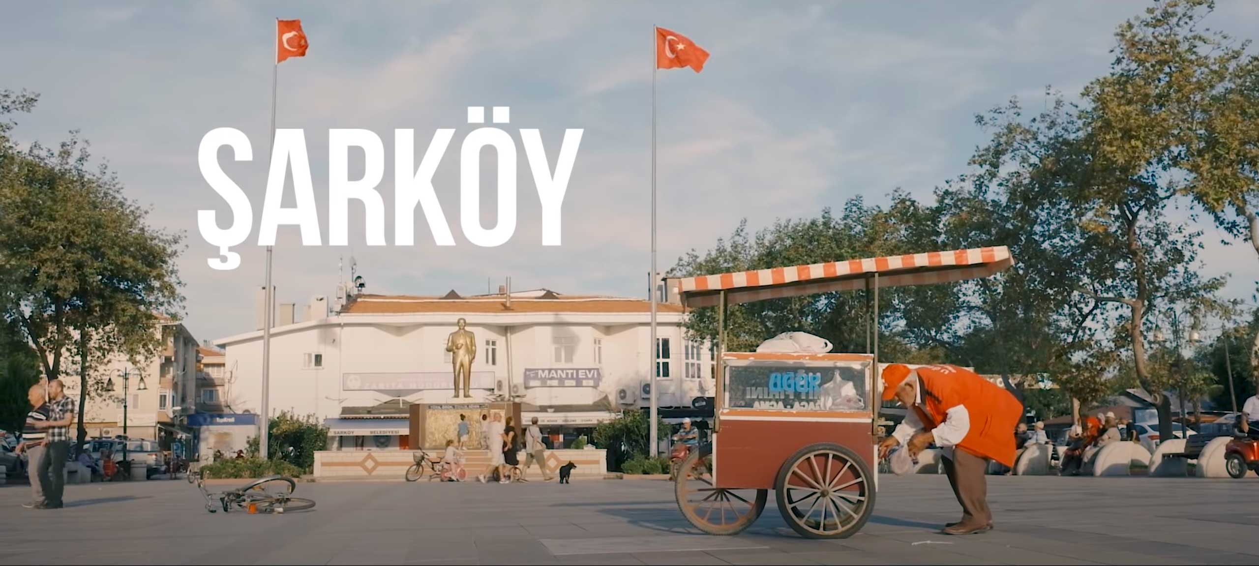 Zentraler Dorfplatz von Sarköy (Tekirdag, Türkei) mit Atatürk-Statue und Simit-Verkäufer und seinem Ziehwagen im Vordergrund